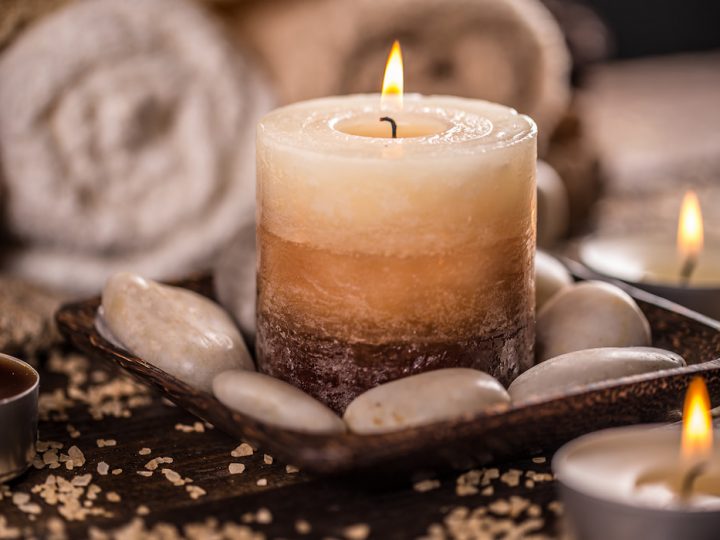 burning candles and stones with blurry towel on the background