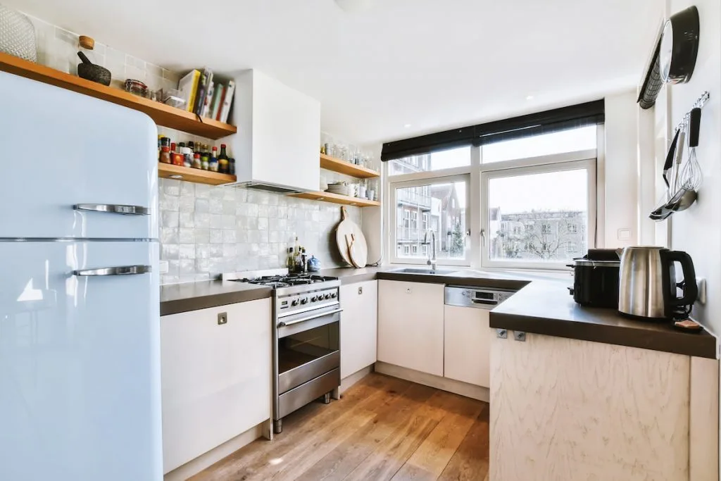 Interior of modern home kitchen with furniture and appliances