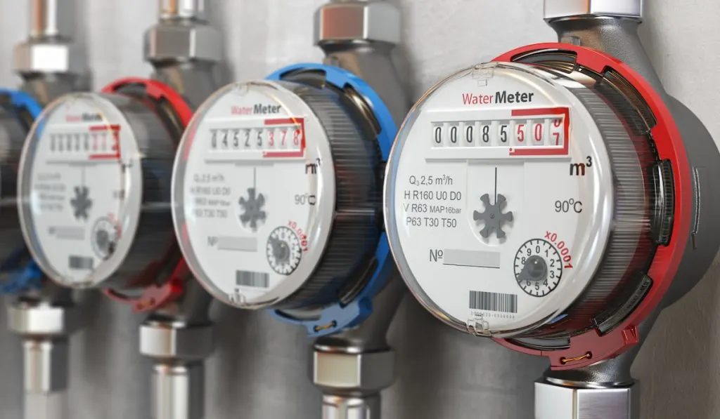Row of water meters of cold and hot water on the wall background
