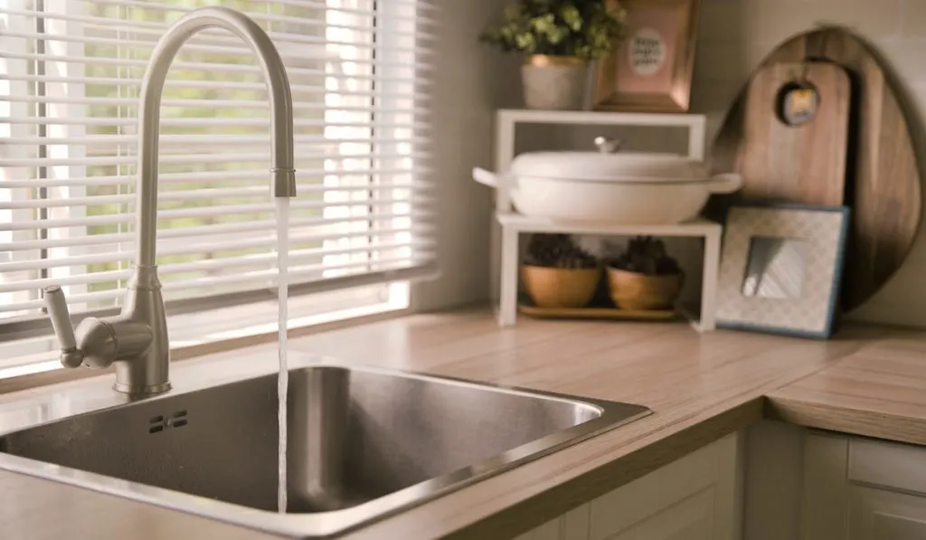 Water running from the faucet into a kitchen sink