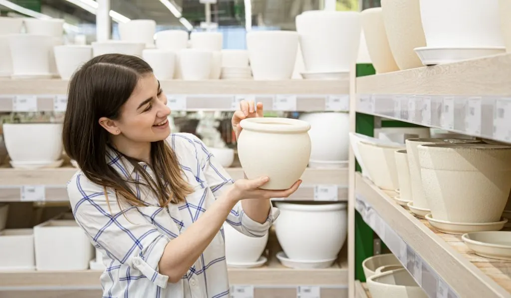 woman choosing a pot for her plant in a pot shop