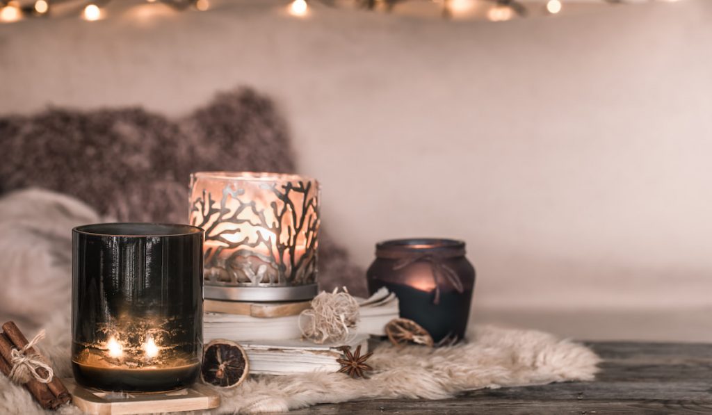 Cozy interior of a room with beautiful candles and a book on the table