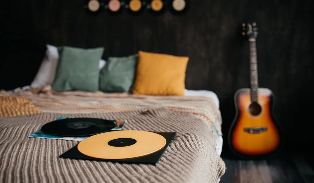 Vinyl records on a bed in a cozy room
