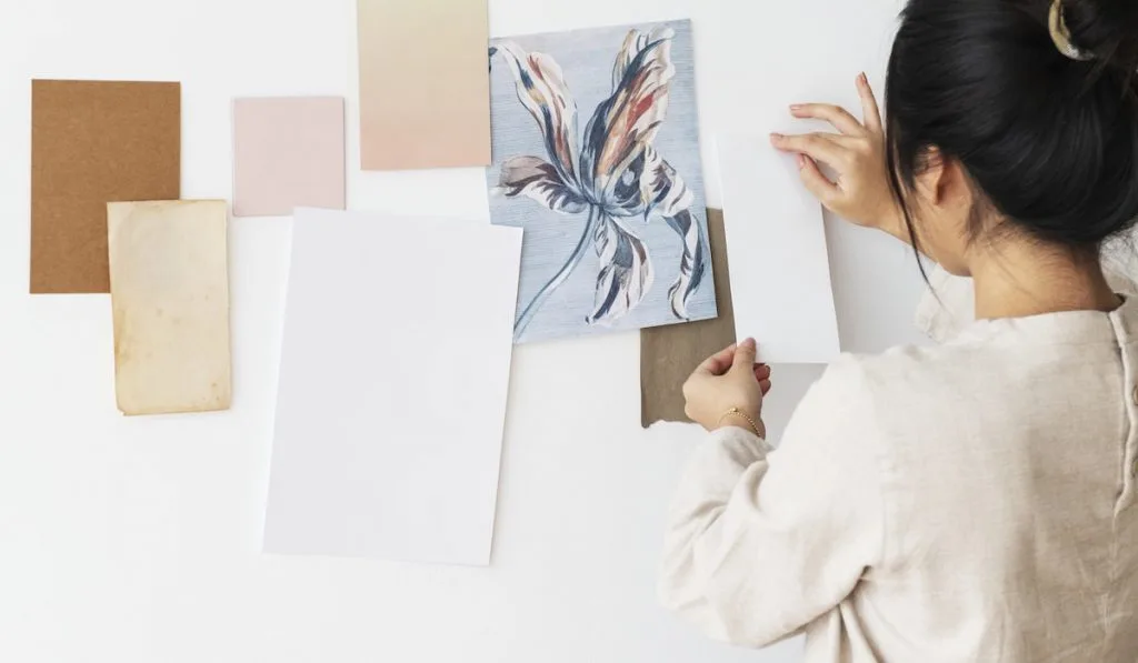 woman attaching a plain white paper to a wall